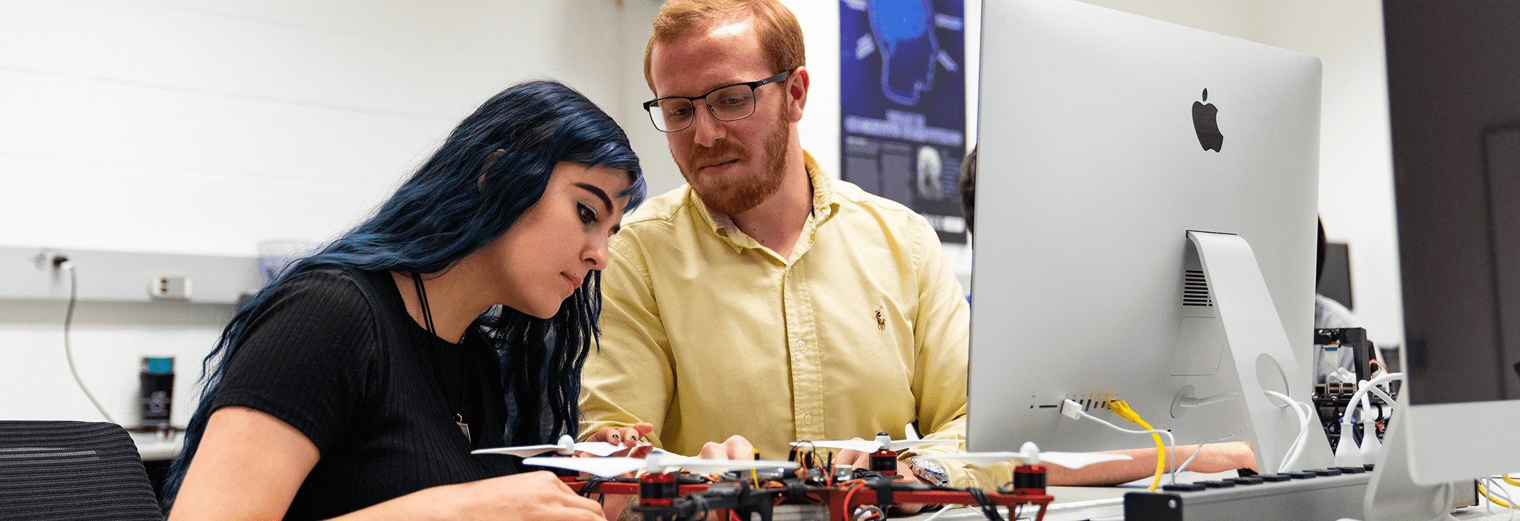 An instructor aids a student with a drone