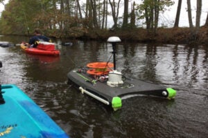 Research conducted by CSE3 staff in a lake. Photo displaying boats to collect data and a man in a kayak.