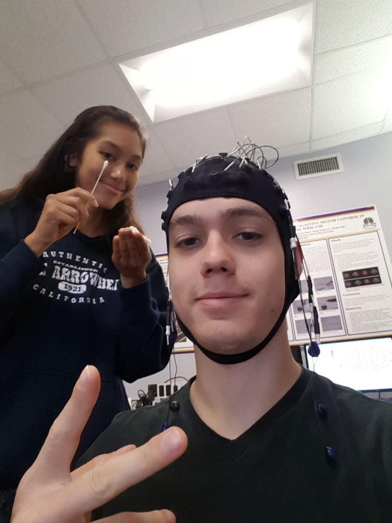 student with a cap with wires on his head