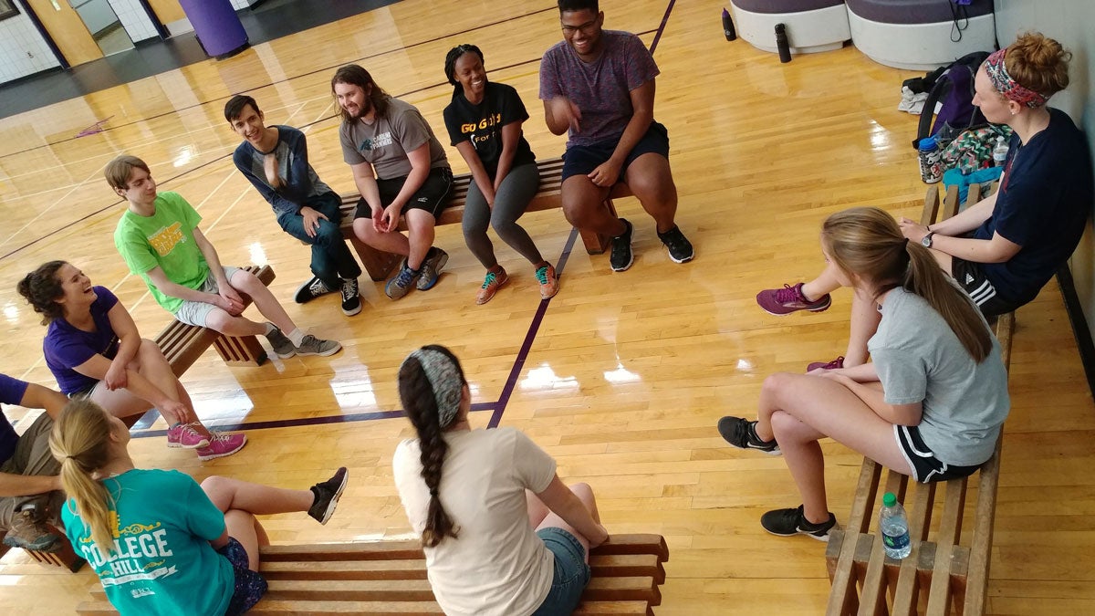 Group of students sitting on benches in a gymnasium