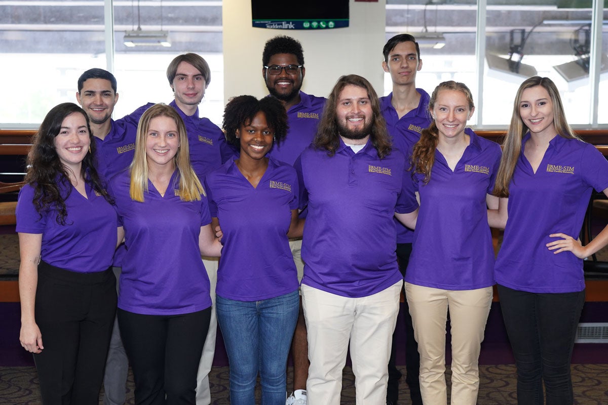 Group of students wearing purple BME-SIM polo shirts