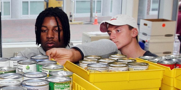 East Carolina University students Myles Berry, left, and Jack Hunike help stack food from the ‘a little heart goes a long way’ food drive Monday, March 2, 2020, in the Industrial Distribution and Logistics  student service learning lab in the Science and Technology Building. (Photo by Ken Buday)