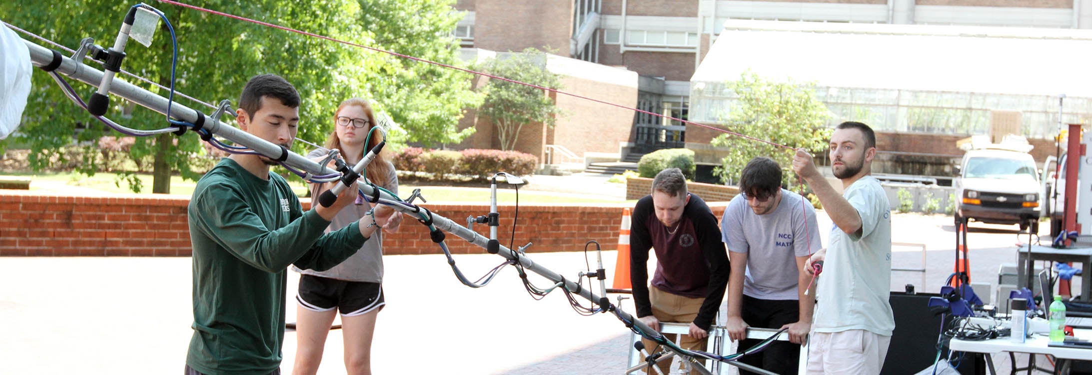 Research students check sound equipment on campus in May. Dr. Teresa Ryan is conducting sound propagation research for the Navy and received a $370,000 grant from the Office of Naval Research to continue her work. (Photo by Ken Buday)