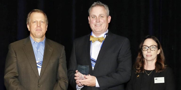 Dr. David Batts center,, associate professor at East Carolina University, accepts the the John R. Bourne award for outstanding online program for ECU’s Bachelor of Science in Industrial Technology program at the Online Learning Consortium Accelerate Conference in Orlando, Florida. (Contributed photo)