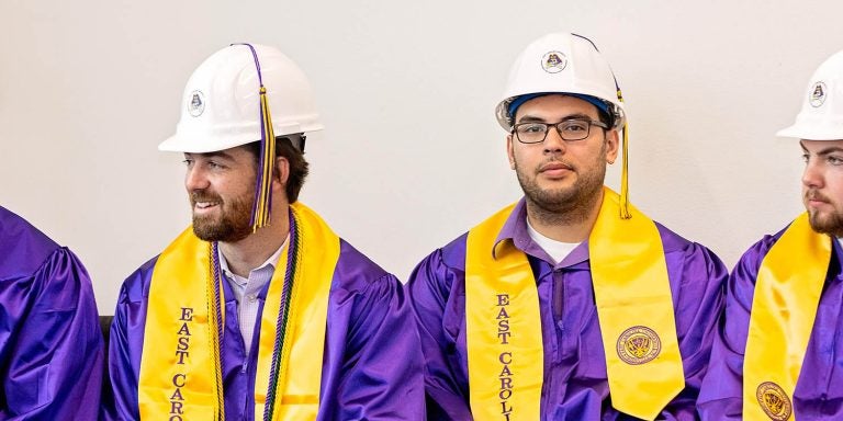 Construction Management graduates are shown in their traditional hard hats during commencement in December. Spring 2020 graduates will receive their hard hats by mail. (Photo by Cliff Hollis)