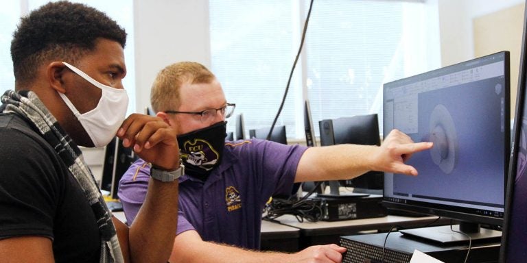 East Carolina University graduate student Drew Thomas helps Cpl. Trevonn Caesar with a design during additive manufacturing training in the Science and Technology Building. (ECU photos by Ken Buday)