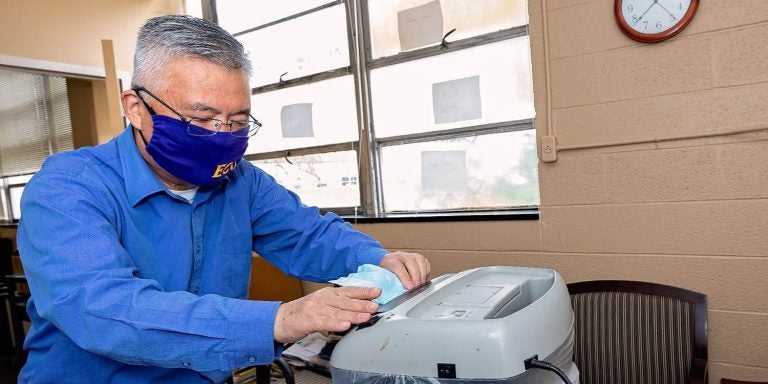Dr. George Wang shreds surgical masks. This is part of research to determine if masks from the pandemic can be used as filler with asphalt. (ECU Photo by Cliff Hollis)