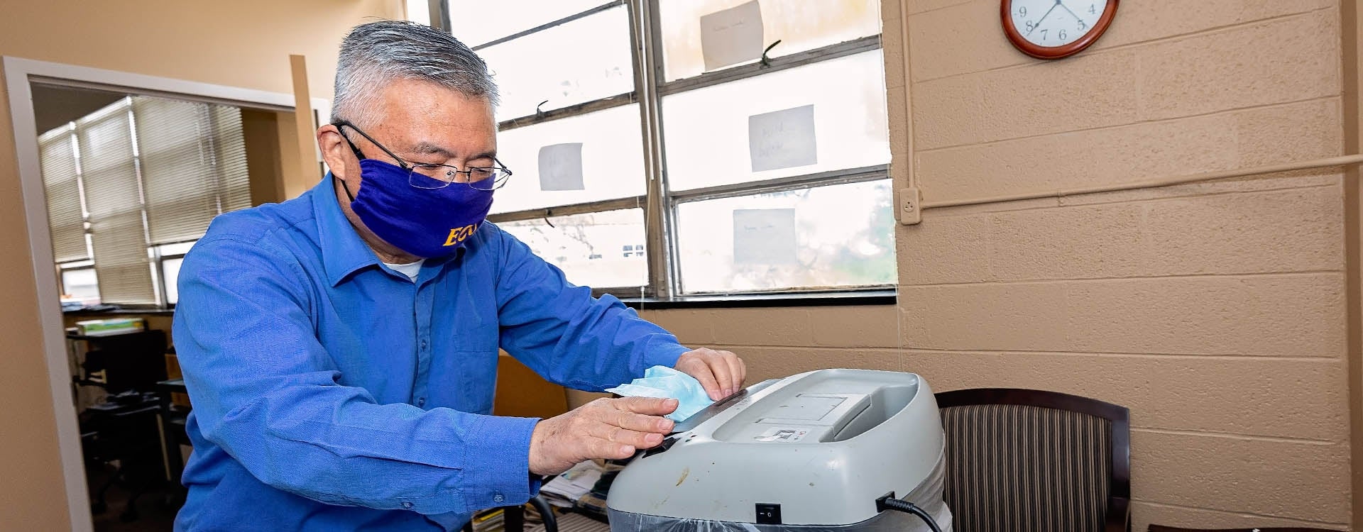 Dr. George Wang shreds surgical masks. This is part of research to determine if masks from the pandemic can be used as filler with asphalt. (ECU Photo by Cliff Hollis)