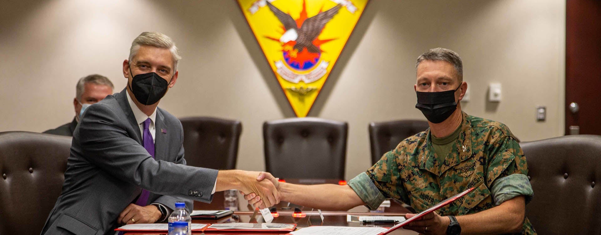 ECU Chancellor Philip Rogers, left, and Col. Mikel Huber, commanding officer at Marine Corps Air Station Cherry Point, shake hands after signing an agreement that will allow university courses to be taught on the base. (Marine Corps photos by Lance Cpl. Jacob Bertram)