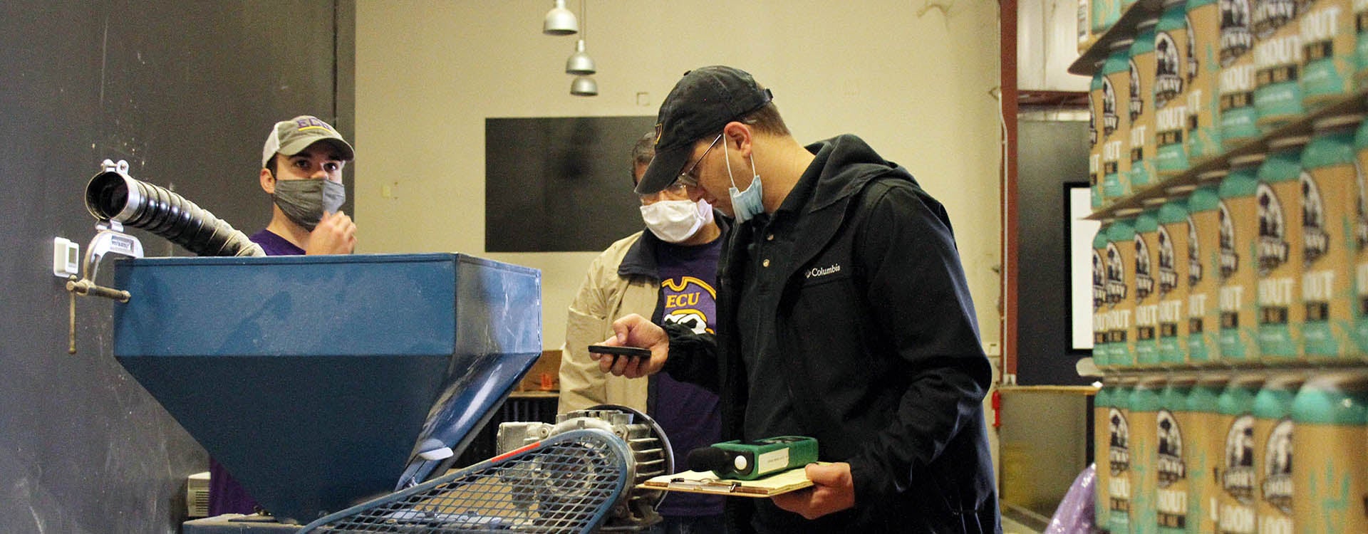 Engineering students Michael Trapani, right, and Kenneth Weddle, along with Dr. Tarek Abdel-Salam, director of the East Carolina University Center for Sustainable Energy and Environmental Engineering, examine equipment during an energy audit at Shortway Brewing. (Photos by Ken Buday)