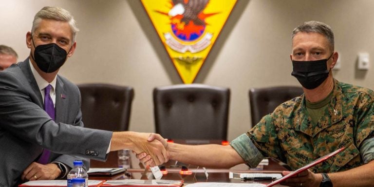 ECU Chancellor Philip Rogers, left, and Col. Mikel Huber, commanding officer at Marine Corps Air Station Cherry Point, shake hands after signing an agreement that will allow university courses to be taught on the base. (Marine Corps photos by Lance Cpl. Jacob Bertram)