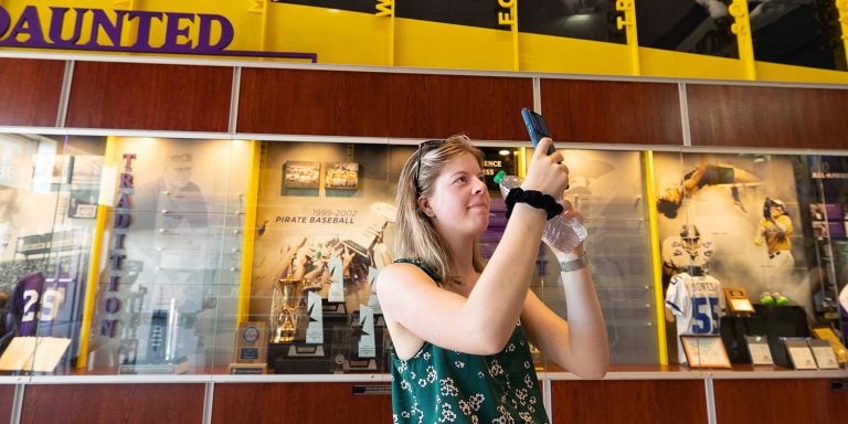 Jarieke de Haas, a student from the Netherlands, takes a video of the Hall of Fame display cases at Minges Coliseum. (Photo by Rhett Butler)