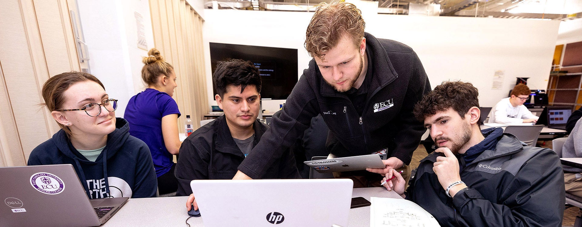 Engineering student Colin Foley, center, works  as a teacher's assistant in an introductory engineering class. Foley, a sophomore, interned with Richard Childress Racing, one of NASCAR's most successful teams. (Photo by Rhett Butler)