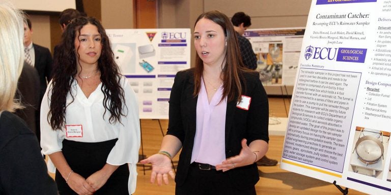 Engineering students Leah Hulett, right, and Victoria Rivera-Mangual explain their rainwater sampler project during the Engineering Capstone Symposium at the Main Campus Student Center. (Photos by Ken Buday)