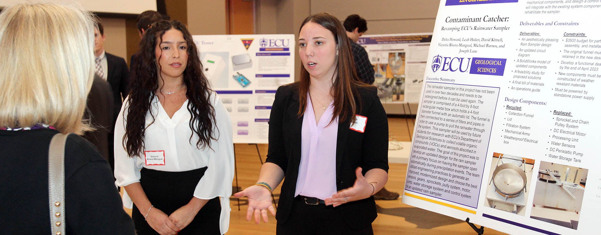 Engineering students Leah Hulett, right, and Victoria Rivera-Mangual explain their rainwater sampler project during the Engineering Capstone Symposium at the Main Campus Student Center. (Photos by Ken Buday)