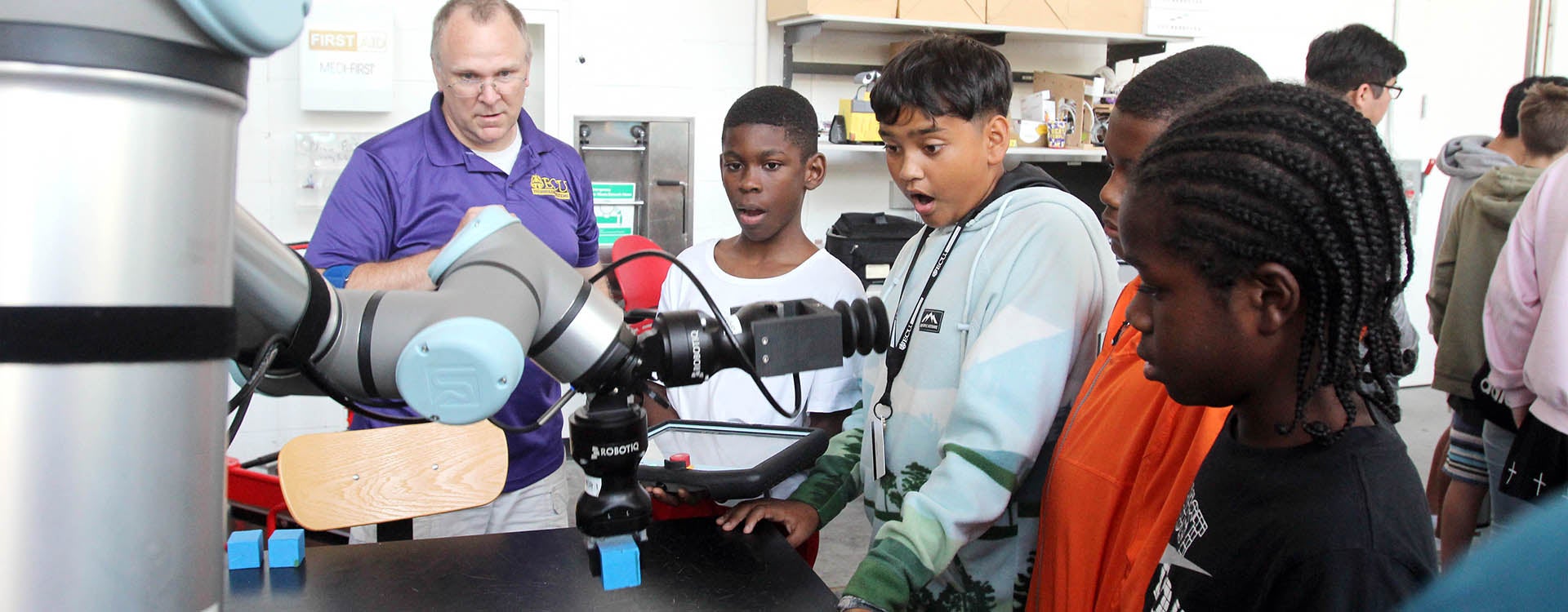 Students react as they operate a cobot to lift a block during the STEMx youth camp in the Science and Technology Building. ECU's Department of Technology Systems received a grant for the camp that is designed to create interest in technology among youth. (Photos by Ken Buday)